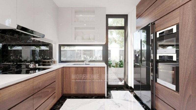 Là một trong những xu hướng thiết kế nội thất nổi bật trong những năm tới, bố trí phòng bếp hiện đại tôn lên vẻ đẹp mộc mạc nhưng không kém phần sang trọng của gỗ điển hình là gỗ óc chó. Loại gỗ rất được ưa chuộng trong các siêu xe bởi vẻ đẹp ấn tượng từ vân, màu gỗ. Như trong ý tưởng thiết kế phòng bếp tại biệt thự Vinhomes Imperia Hải Phòng, sự hài hòa tôn lên nét đẹp giữa truyền thống và hiện đại, tủ bếp dưới gỗ óc chó và tủ bếp trên gỗ công nghiệp trắng bóng. Tủ bếp gỗ công nghiệp và tủ bếp acrylic